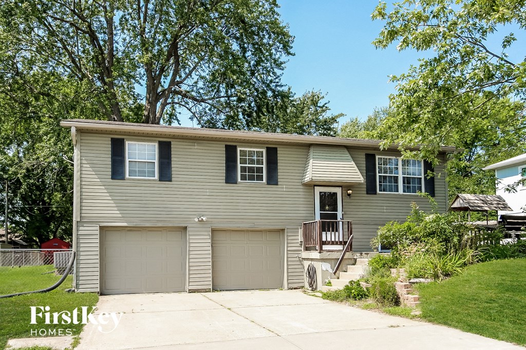 a gray house with a garage door and a porch