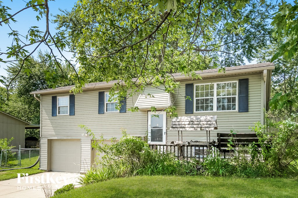 a yellow house with a yard and a white fence