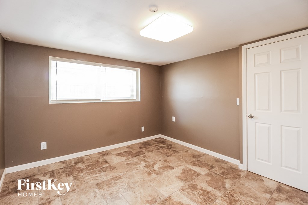 the bedroom of a home with a white door and a window