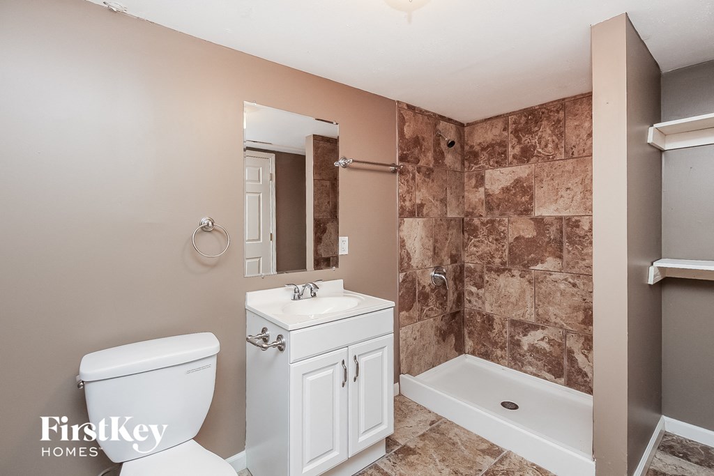 a bathroom with a toilet and a sink and a shower