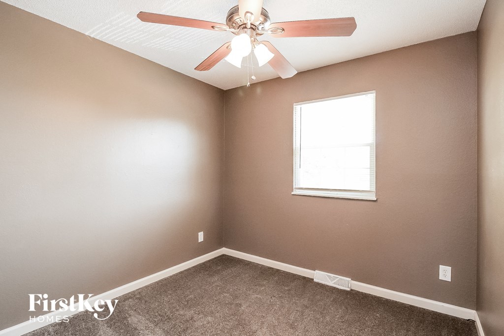 a bedroom with a ceiling fan and a window