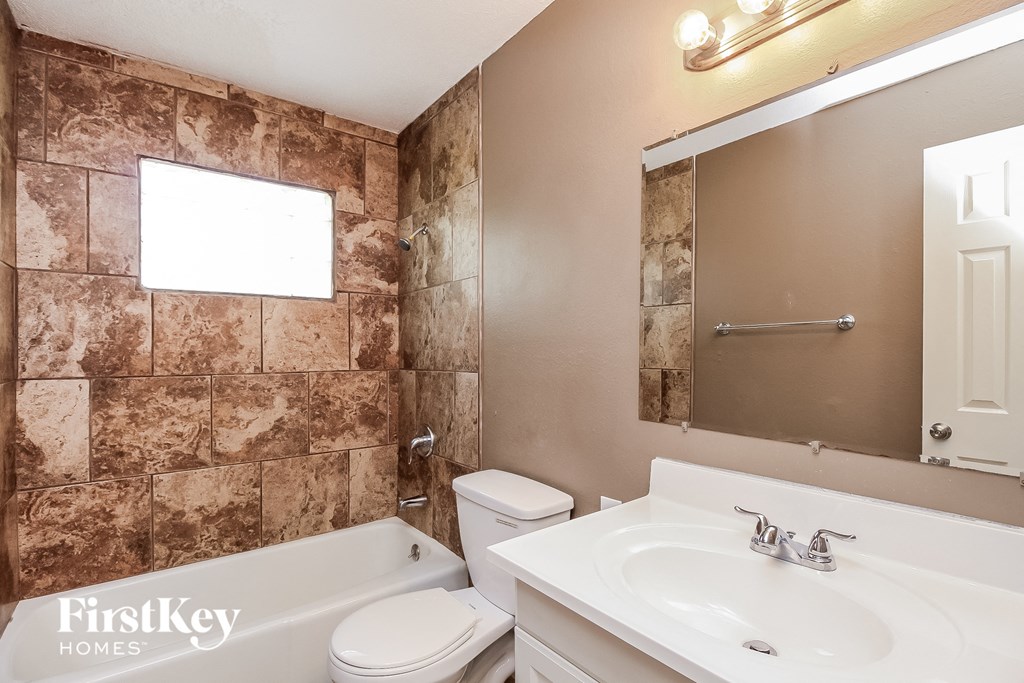 a bathroom with a sink toilet and tub and a mirror