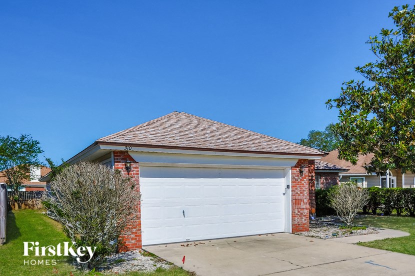 A house with a white garage door and a brick chimney.