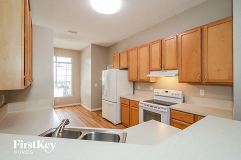 A kitchen with wooden cabinets and white appliances.