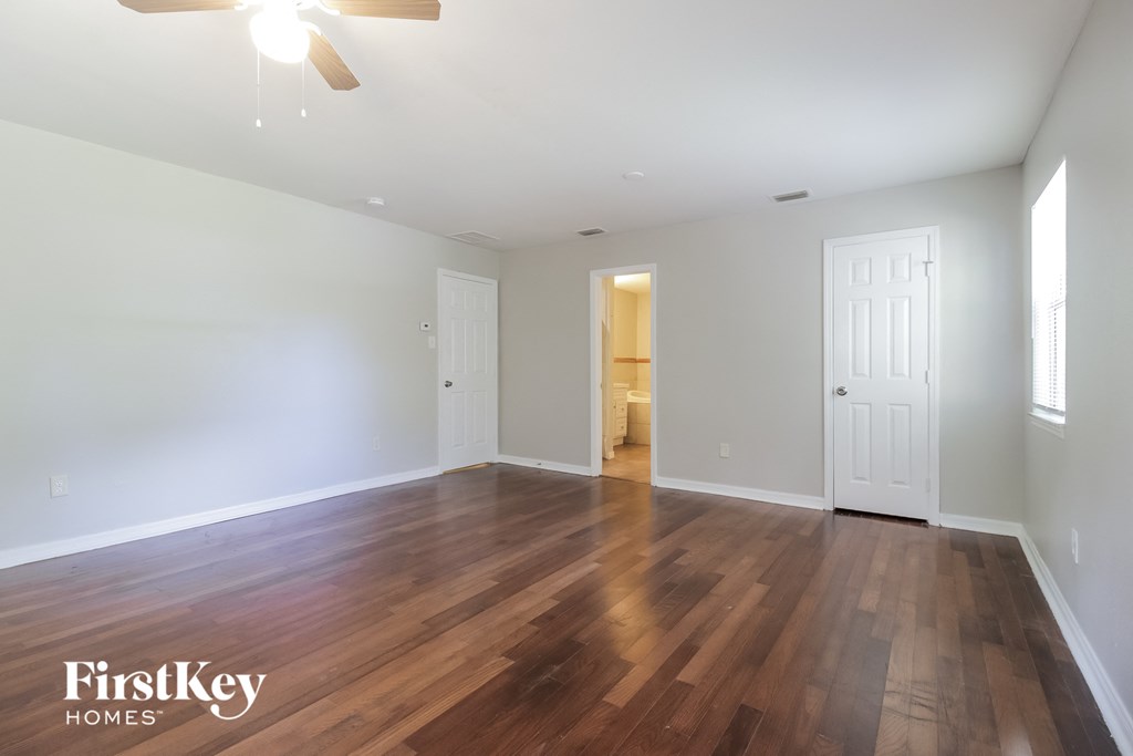 a living room with a hard wood floor and white walls