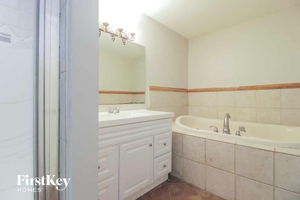 a bathroom with a tub and a sink and a mirror