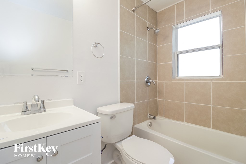 a white bathroom with a toilet and a tub and a sink