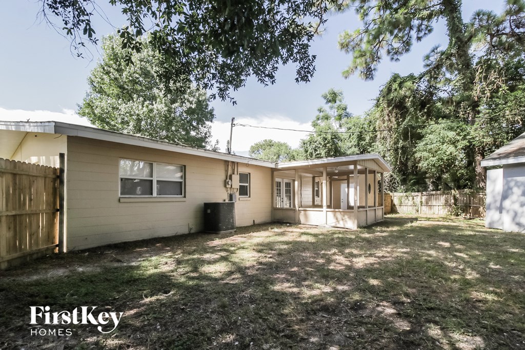 the exterior of a house with a yard and a wood fence