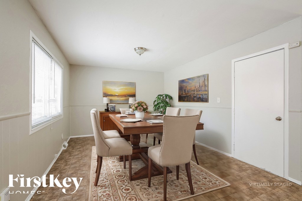A dining room with a wooden table and chairs.