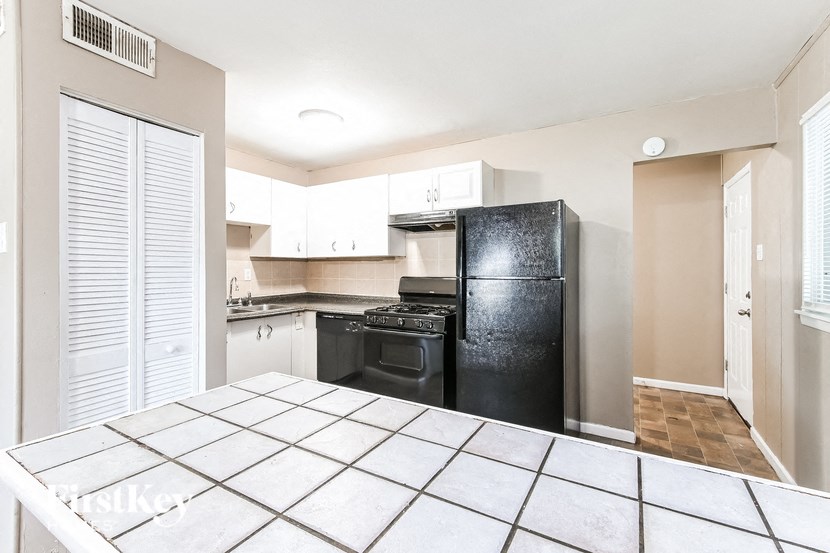 a kitchen with a black refrigerator and a black stove