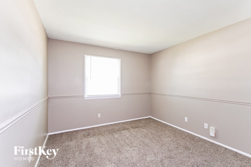 a large room with carpet and a window