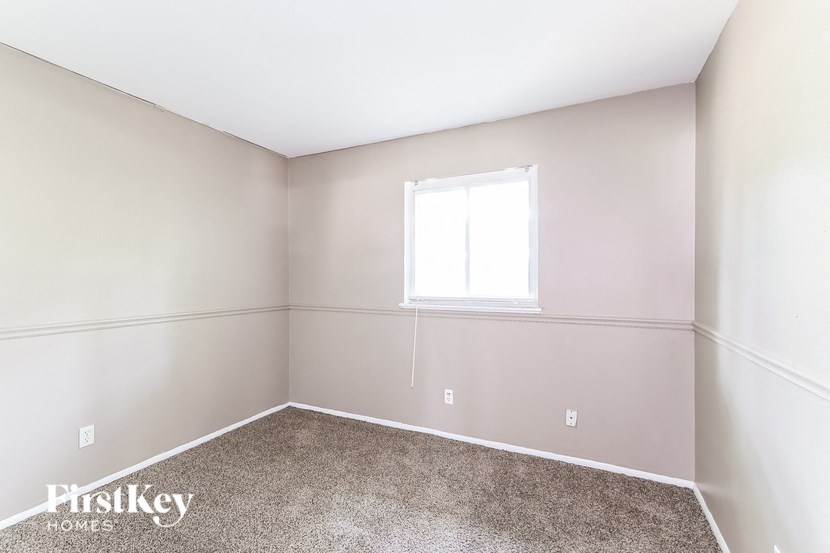 a empty room with a window and carpet