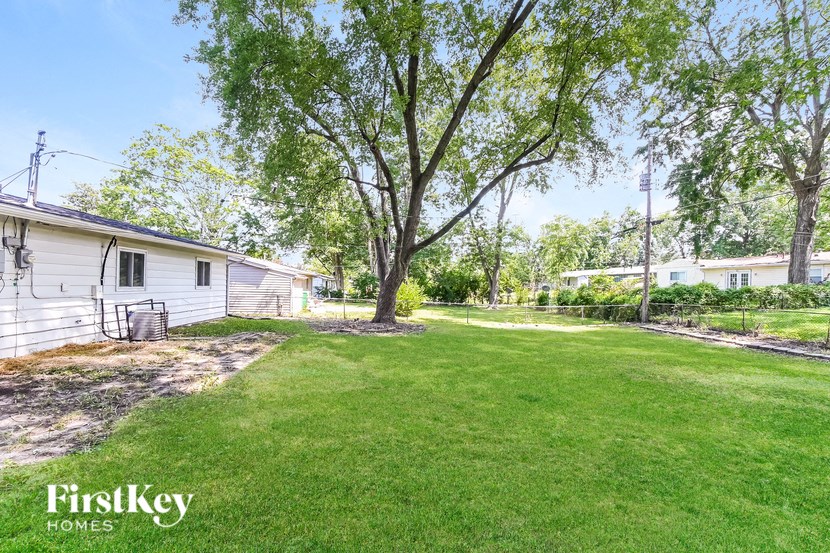 a backyard with a house and a yard with grass and trees