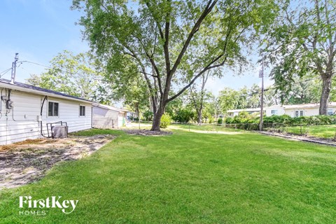 a backyard with a house and a yard with grass and trees