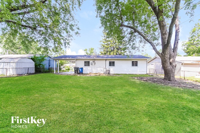 a white house with a yard and a tree