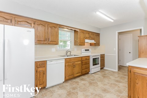 A kitchen with wooden cabinets and a white fridge.