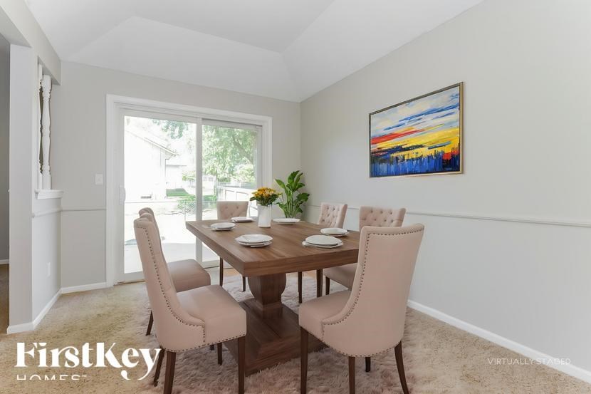 A dining room with a wooden table and chairs.
