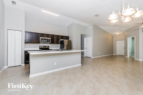 a kitchen and living room with a counter top and a refrigerator