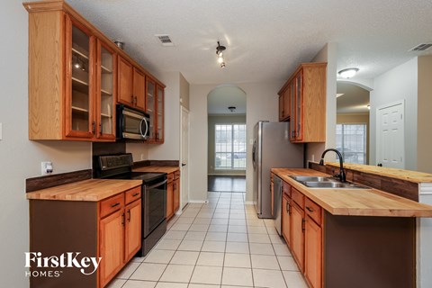 a kitchen with wooden cabinets and a sink and a refrigerator