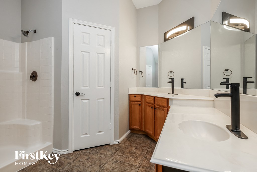 a bathroom with a sink and a mirror and a shower