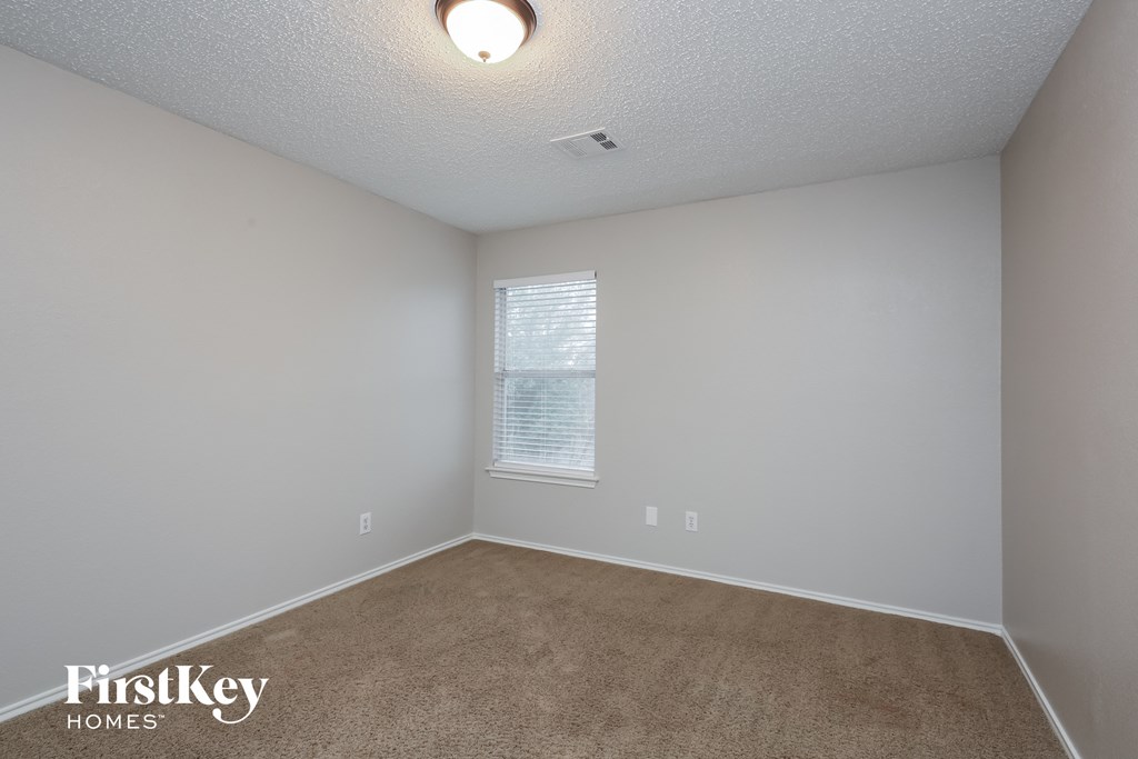 a bedroom with a carpeted floor and a window