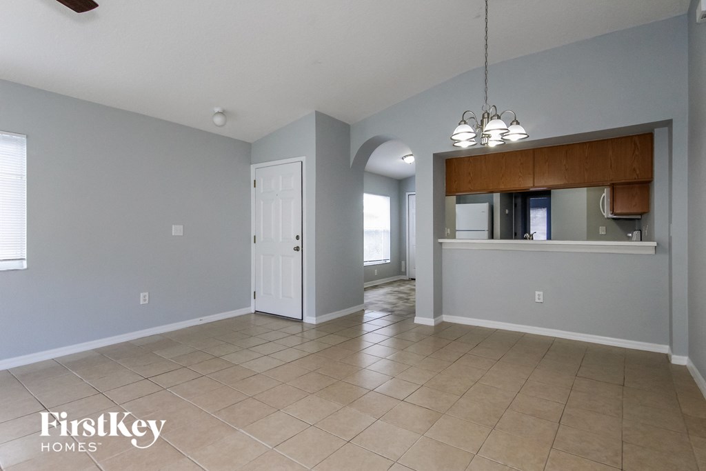a kitchen and living room with tile flooring and grey walls