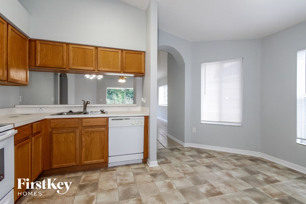 an empty kitchen with wooden cabinets and white appliances