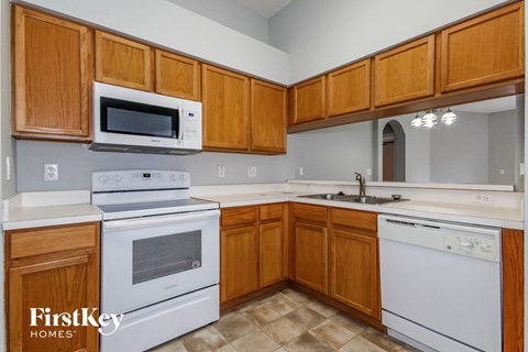 a kitchen with white appliances and wooden cabinets