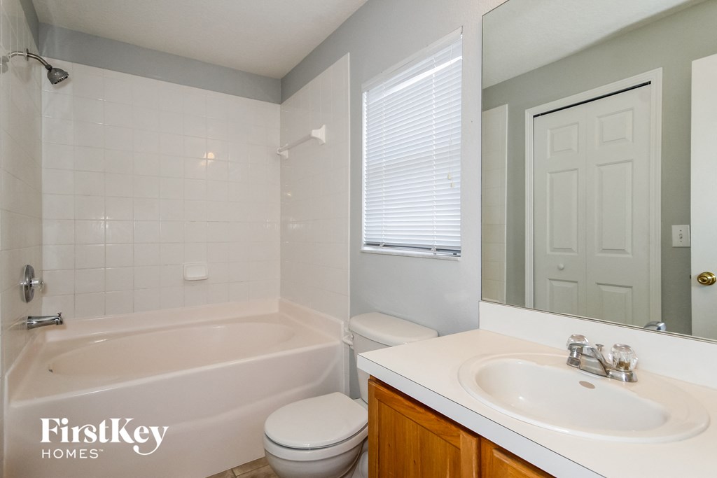 a bathroom with a sink toilet and tub and a mirror