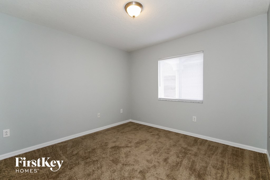 a bedroom with a carpeted floor and a window