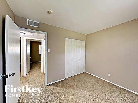 a bedroom with a closet and a door to the bathroom