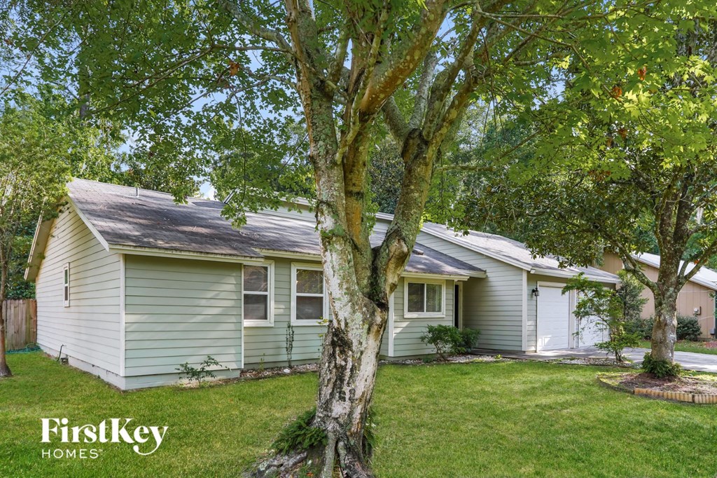 A tree in front of a house with the words "FirstKey Homes" on the bottom left.