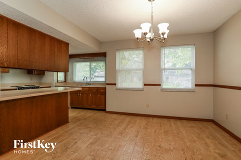 A kitchen with wooden cabinets and a wooden floor.