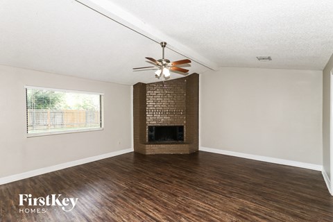 A room with a fireplace and a ceiling fan.