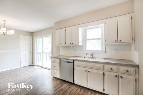 a kitchen with white cabinets and a sink and a window
