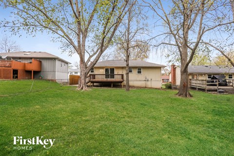 a backyard with some trees and a house