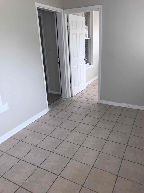 a large tiled floor in a room with an open door