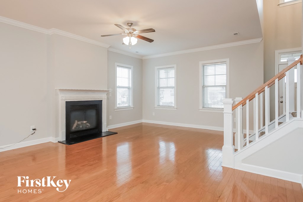 A spacious room with a fireplace and a staircase.