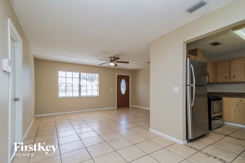 A kitchen with a refrigerator and a ceiling fan.