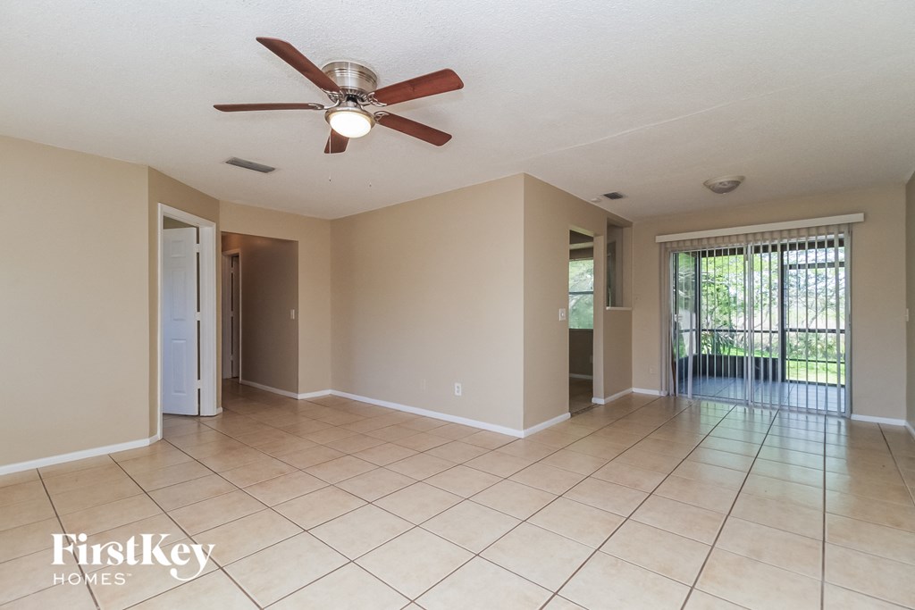 A spacious room with a ceiling fan and tiled floor.