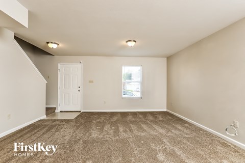 A room with a carpeted floor and a white door.