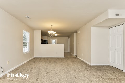 A spacious room with a chandelier and a white door.