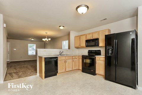 A kitchen with black appliances and wooden cabinets.