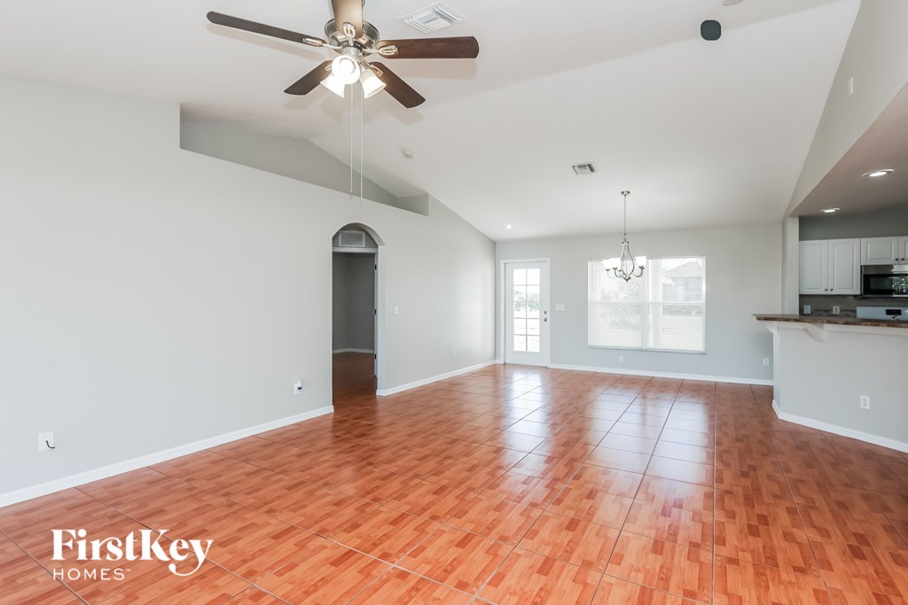 A spacious room with a ceiling fan and wooden flooring.
