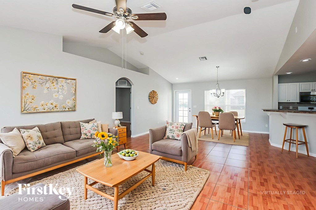 A living room with a grey couch, a wooden coffee table, and a ceiling fan.