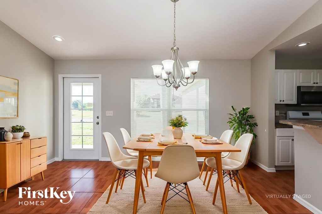 A dining room with a wooden table and chairs.