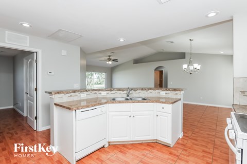 A kitchen with a white counter and cabinets.
