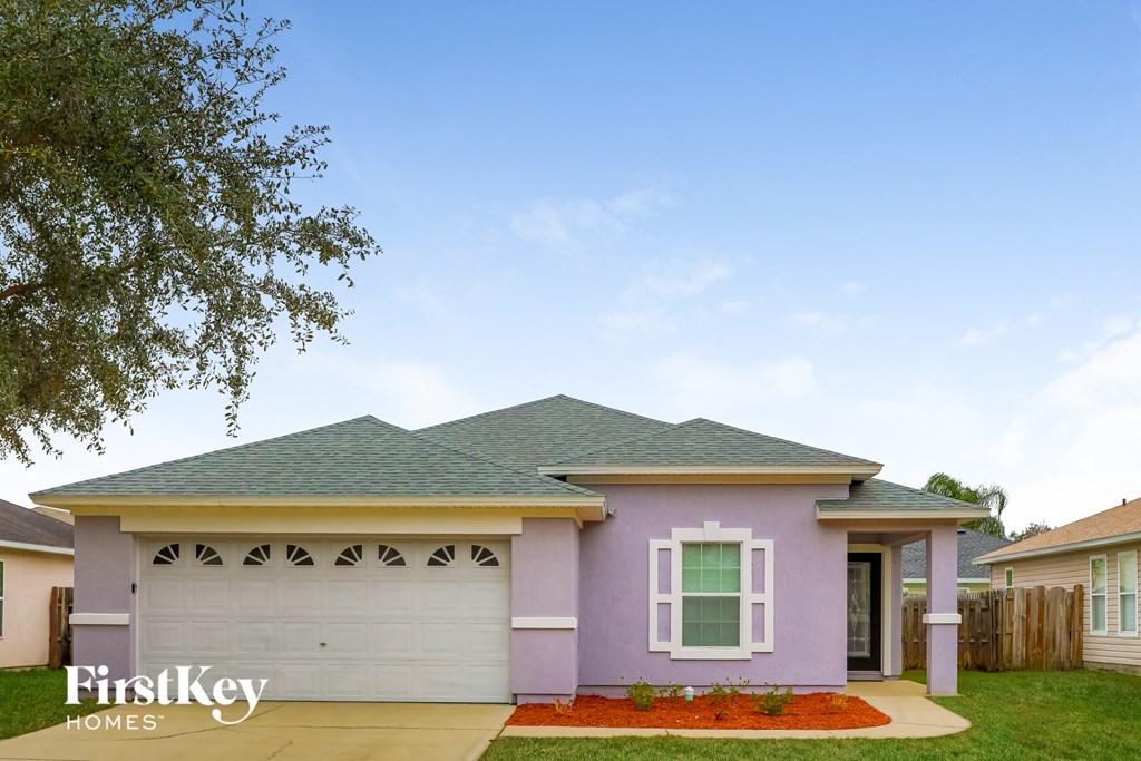 A purple house with a white window and a white garage door.
