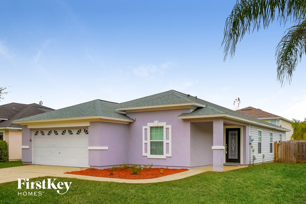 A house with a purple front and a white garage door.