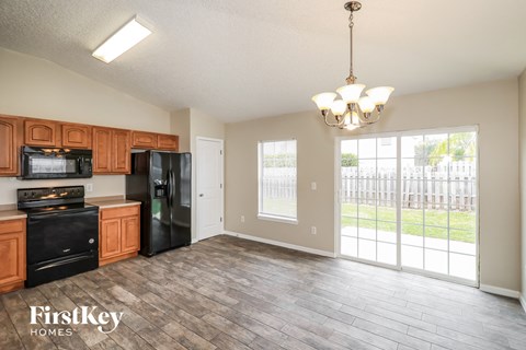 A kitchen with wooden cabinets and black appliances in a house.